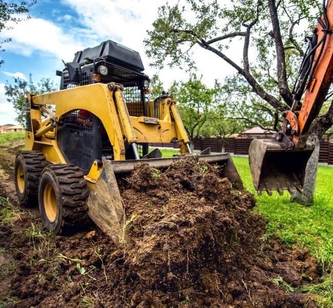 Yellow mini bulldozer working with earth