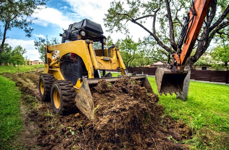 Yellow mini bulldozer working with earth