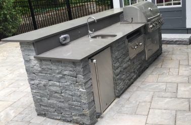 Outdoor kitchen island with sink and grill