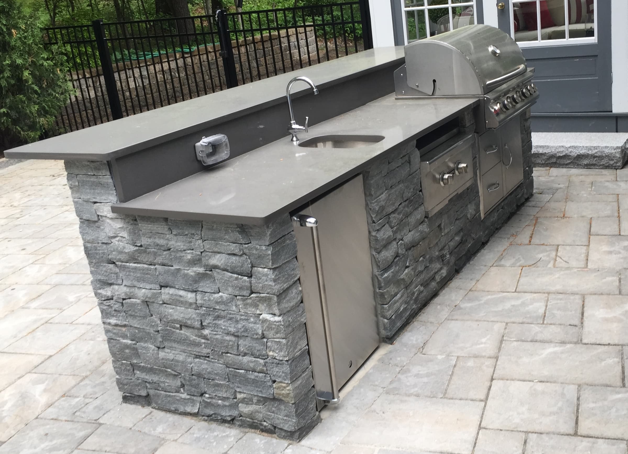 Outdoor kitchen island with sink and grill