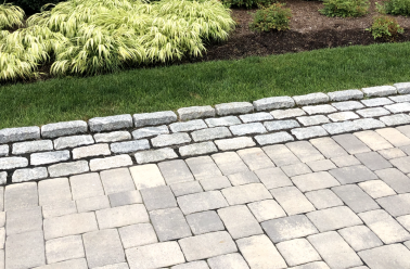 plantings by stone work driveway