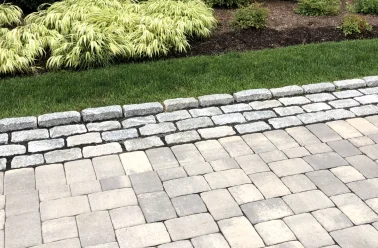 plantings by stone work driveway