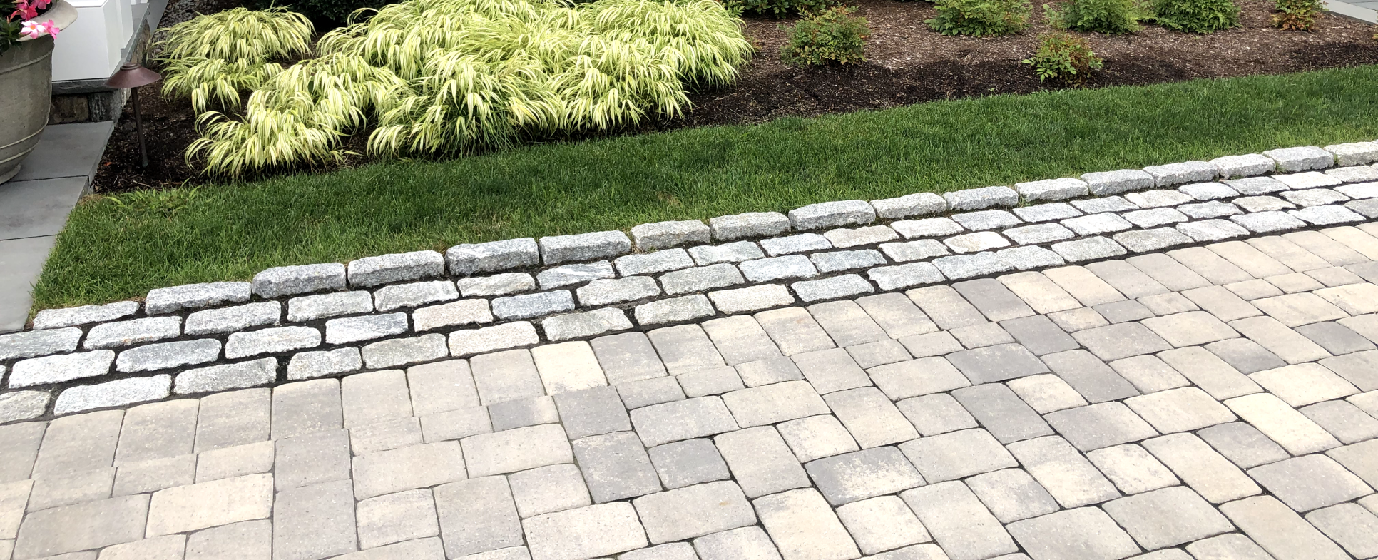 plantings by stone work driveway